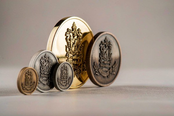 Custom challenge coins in different sizes and plating finishes compared side by side